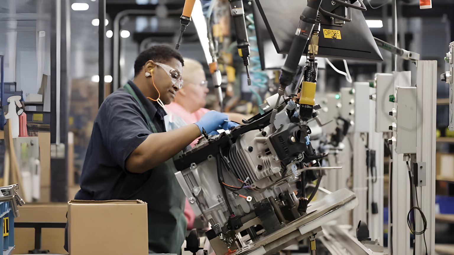 Assembly line worker building small engines at a manufacturing plant